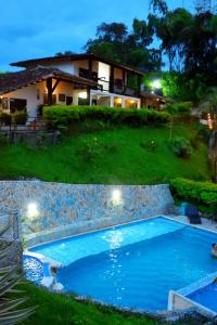 a large swimming pool in front of a house at Finca Hotel Loma Verde in Quimbaya