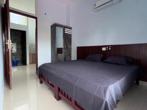a bedroom with a bed in a white room at DEN LODGE in Kulasegaram