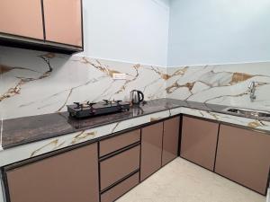 a kitchen with marble counter tops and a sink at DEN LODGE in Kulasegaram