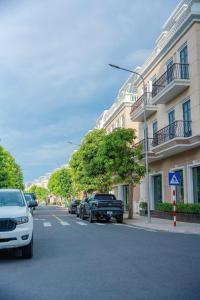 a street with cars parked in front of a building at Tuỳ Tâm Luxury Hotel Quảng Trị in Ðông Hà