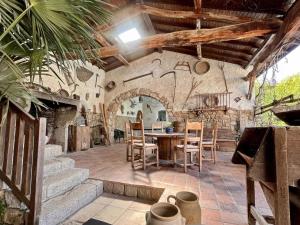 una cocina con mesa y sillas en un edificio en Domaine de Campagne : Charme Authentique avec Piscine et Spa - FR-1-496-364, en Essertines-en-Donzy