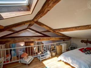 Un dormitorio abuhardillado con vigas de madera y una cama. en Domaine de Campagne : Charme Authentique avec Piscine et Spa - FR-1-496-364, en Essertines-en-Donzy 27 fotos más