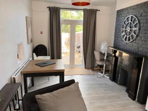 a living room with a fireplace and a table at Abbey Wood Residence in Abbey Wood