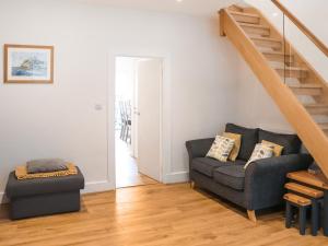 a living room with a couch and stairs at Trem Y Mor in Criccieth