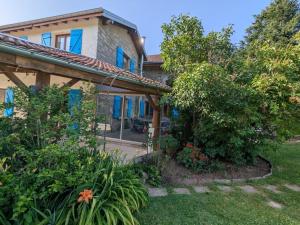 ein Haus mit blauen Fenstern und einem Garten in der Unterkunft Maison spacieuse avec spa, ping-pong et baby-foot, idéale pour détente en famille - FR-1-589-828 in La Chapelle-aux-Bois