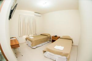 a hospital room with two beds and a window at Fragata Apart Hotel in Marília