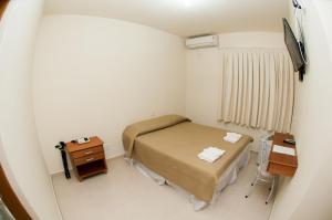 a small room with a bed and a television at Fragata Apart Hotel in Marília