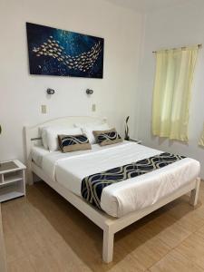 a bedroom with a large bed with a painting on the wall at Reef Waters Resort in Pilar +43 photos