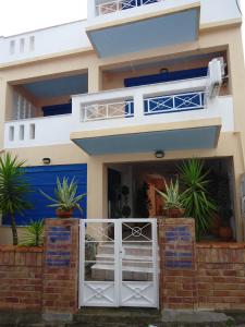 a house with a white door and potted plants at Onar in Limne