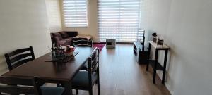 a living room with a table and chairs and a couch at Departamento en condominio privado Puerto Montt in Puerto Montt