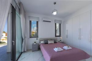 ein Schlafzimmer mit einem Bett mit zwei Handtüchern darauf in der Unterkunft Luxury Paphos Villa Villa Adaris 5 Bedroom Villa Private Swimming Pool in Peyia + 32 Fotos
