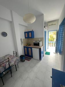 a kitchen with blue cabinets and a white tile floor at Hotel Glaros Lipsi in Leipsoi