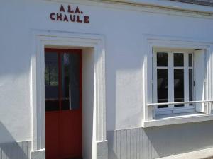 a white building with a red door and a window at Maison charmante au calme avec jardin à Kerlard - FR-1-813-24 in Groix +3 photos