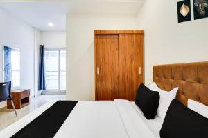 a bedroom with a bed and a wooden door at Townhouse OAK XOTEL near silk board metro in Bengaluru