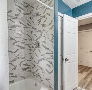 a bathroom with a shower with a fish patterned wall at Stunning, Pet-friendly Home in Savannah in Savannah +5 photos