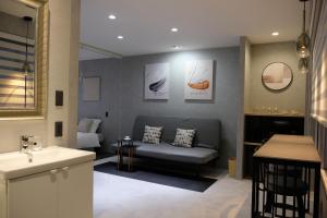 - un salon avec un canapé et un lavabo dans l'établissement Jasmin錦町 4F, à Takamatsu