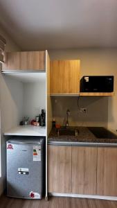 a small kitchen with a refrigerator and a sink at Lovely studio apartment in Cochabamba