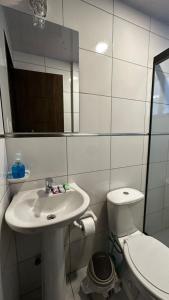 a bathroom with a sink and a toilet and a mirror at Lovely studio apartment in Cochabamba