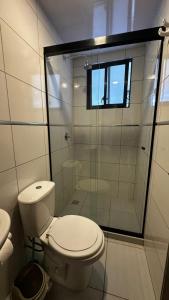 a bathroom with a toilet and a glass shower at Lovely studio apartment in Cochabamba