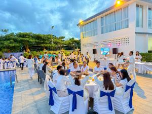 白马市Sangkahak Mith Hotel的一群人围坐在泳池前的桌子旁 更多37张照片