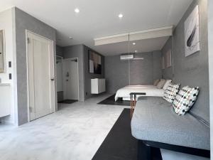 une chambre avec un lit et un canapé dans une pièce dans l'établissement Jasmin錦町 4F, à Takamatsu