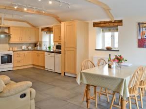 a kitchen with a table and chairs in a kitchen at Tresidder Barn in Constantine