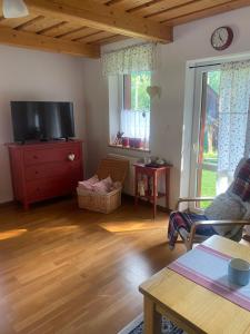 a living room with a tv and a wooden floor at Chalúpka u MAŤA in Terchová