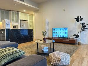 a living room with a couch and a tv at St Mary Residence, Luxury 3B3R Family Suite with Balcony by Lilbean Space in Kuala Lumpur