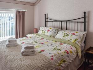 a bedroom with a bed with towels on it at Trem Y Werydd in Amlwch +9 photos