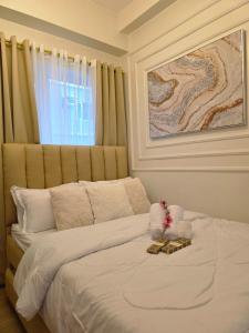 a bedroom with a large white bed with a window at Affordable New Staycation Condo in Quezon City in Manila