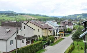 a street in a village with houses at Apartament Pod Łanem in Tylicz