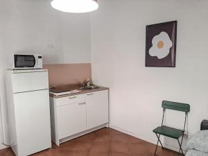 a small kitchen with a microwave and a refrigerator at Beautiful Center Apartments - posti auto privati prenotabili in Parma