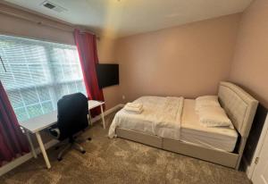 a bedroom with a bed and a desk and a chair at Pprevalon in Gastonia