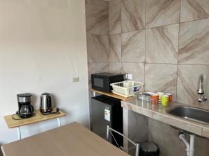 タクナにあるCentro de Tacna quinto pisoのシンクと電子レンジのある小さなキッチン