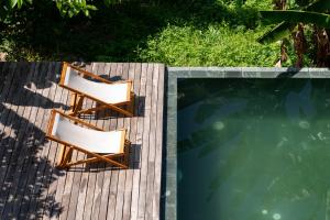 two chairs sitting next to a swimming pool at Scarlet Pavilion in Thôn An Vân Thượng