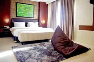 Postel nebo postele na pokoji v ubytování Noormans Hotel Semarang