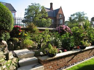un jardín frente a una casa con flores en The Winchester, en Great Yarmouth