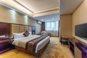 a hotel room with a bed and a flat screen tv at Wuhan Yamao Hengsheng Hotel in Wuhan