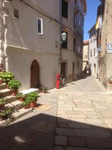an alley with a red fire hydrant next to a building at Apartments Kremenic in Cres
