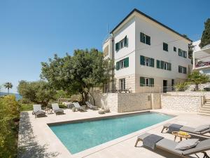 a swimming pool in front of a building at Exclusive Hvar Villa 6 Bedrooms Villa Serenity By The Sea Incredible Sea & Monument Views Jacuzzi in Hvar