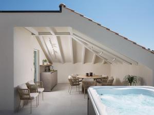 a room with a tub and a table and chairs at Exclusive Hvar Villa 6 Bedrooms Villa Serenity By The Sea Incredible Sea & Monument Views Jacuzzi in Hvar