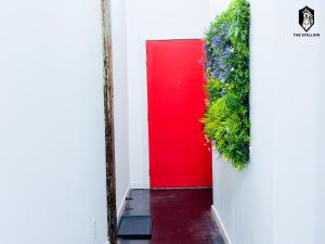孟菲斯The Stallion #101 - 1BD Modern Loft with Private Patio - Walk to various attractions的一扇红门，白色墙壁上种着植物
