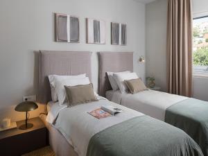 a bedroom with two beds and a window at Exclusive Hvar Villa 6 Bedrooms Villa Serenity By The Sea Incredible Sea & Monument Views Jacuzzi in Hvar +32 photos