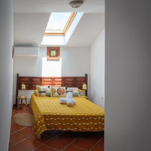 a bedroom with a yellow bed with a skylight at Hamlets Friends Rural House in Nuño Gómez +28 photos