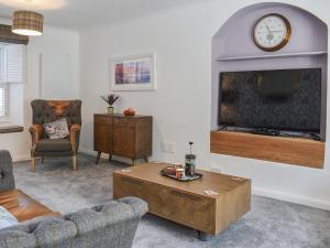 Una sala de estar con un sofá y un televisor. en Bryn Y Felin, en Dyffryn