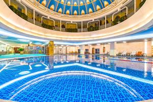 a large swimming pool in a building with a dome at Langfang Arcadia International Hotel in Langfang