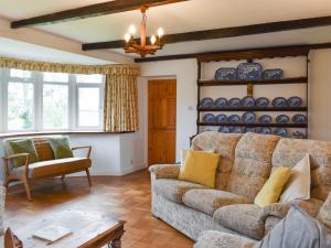 un salon avec un canapé et une table dans l'établissement Keepers Cottage, à Garway