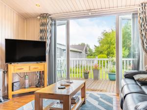 a living room with a tv and a large window at Laurel Lodge in Willington