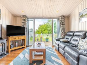 a living room with a couch and a television at Laurel Lodge in Willington