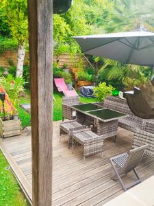 a patio with a table and chairs and an umbrella at Maison avec vu sur le château in Pierrefonds